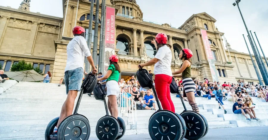 Eine kleine Gruppe mit Helmen auf Segways auf der Terrasse vor dem Palau Nacional